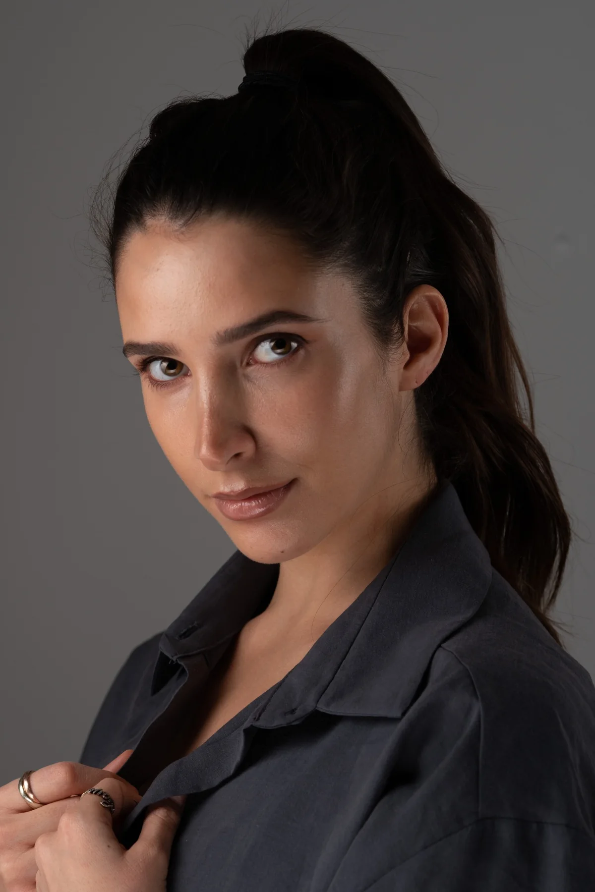 Professional woman in a dark blouse against a grey background