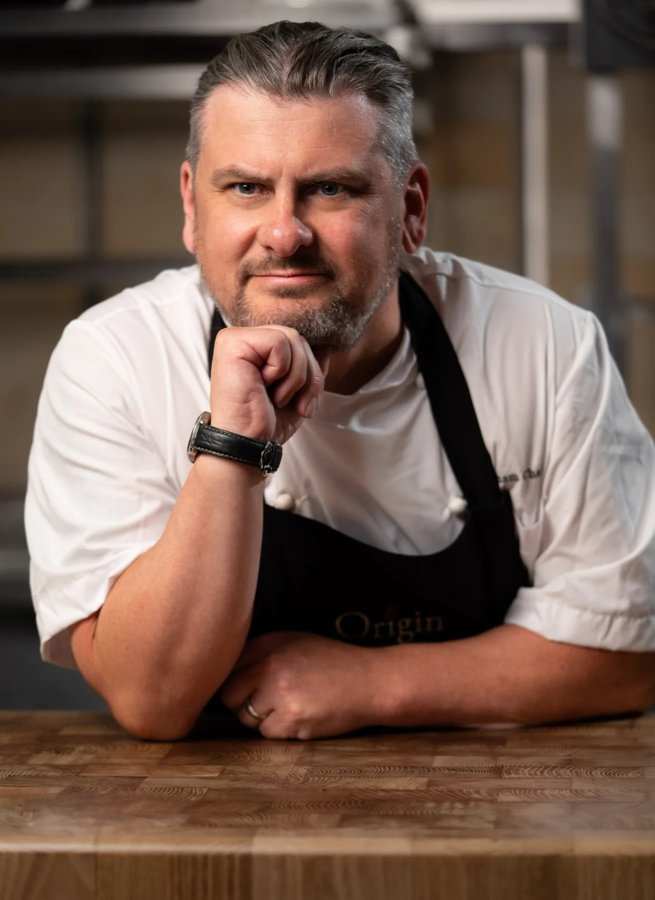 Chef looking at the camera in a working kitchen