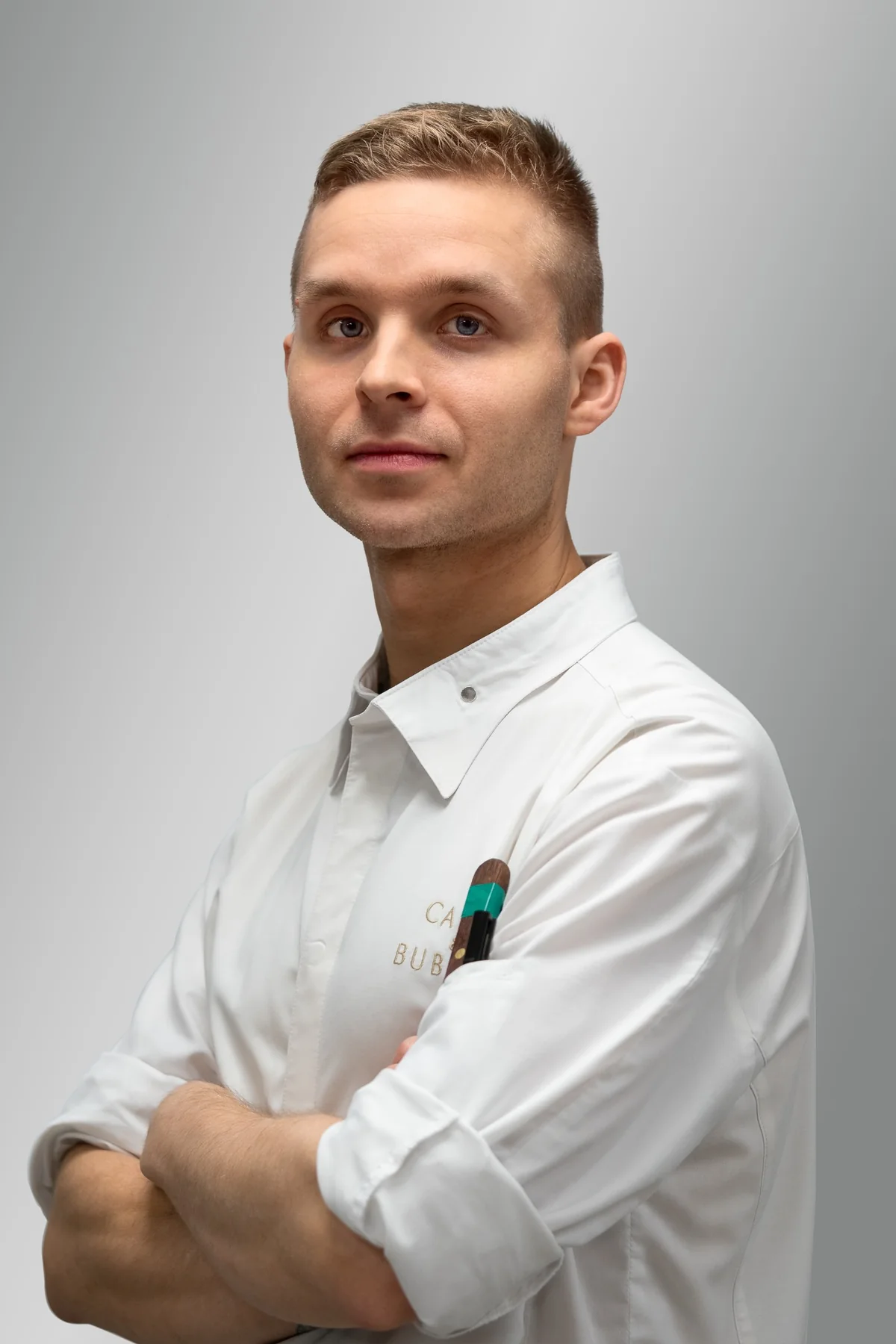 Chef in clean whites photographed against a neutral background